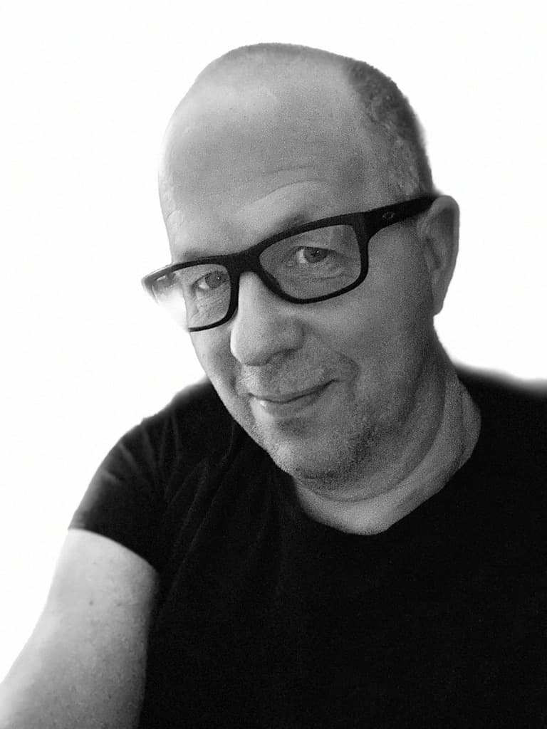 Svartvit närbild på man i svart t-shirt och svarta glasögon och