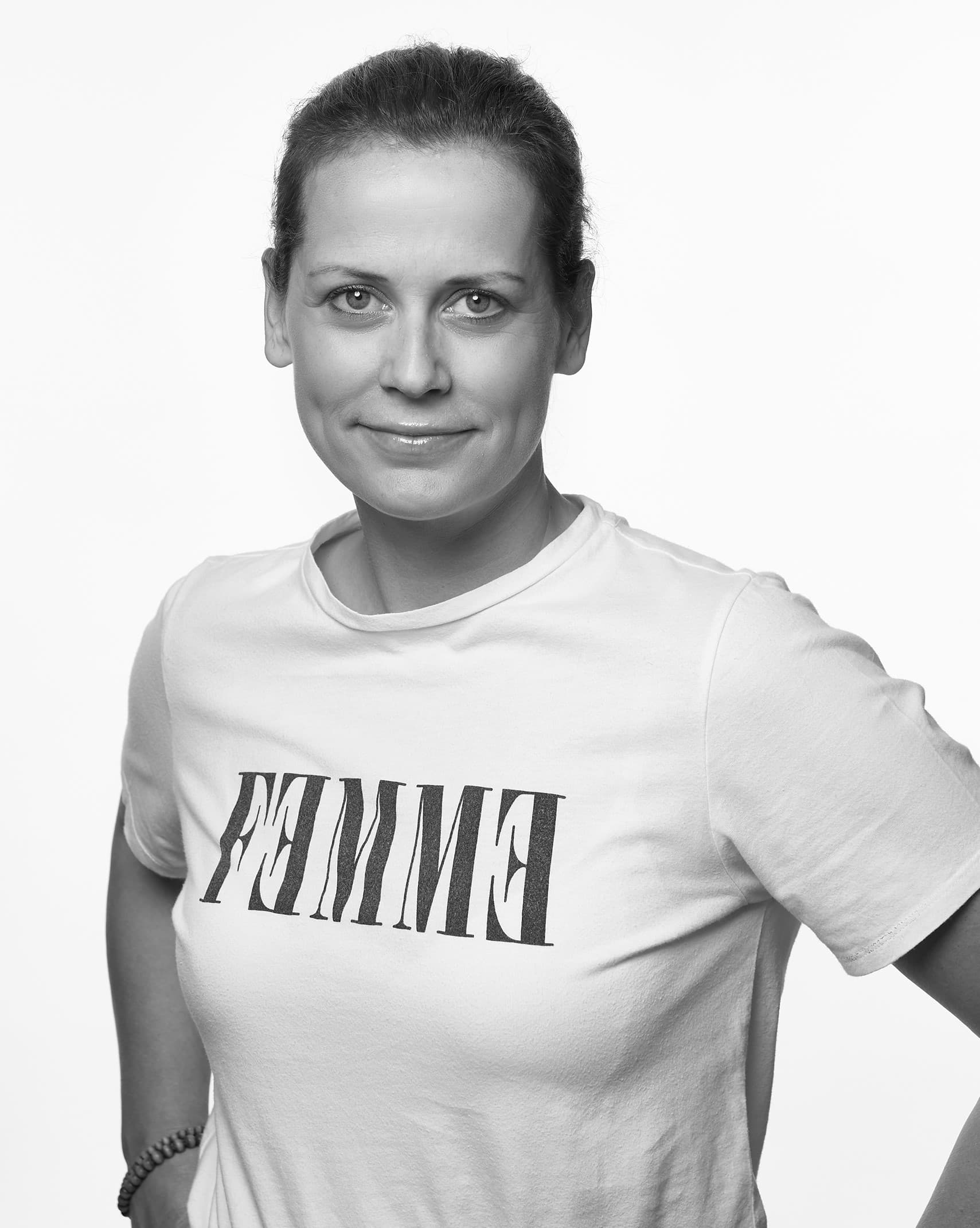 Svartvit bild på kvinna i ram toffs, händerna på höfterna.