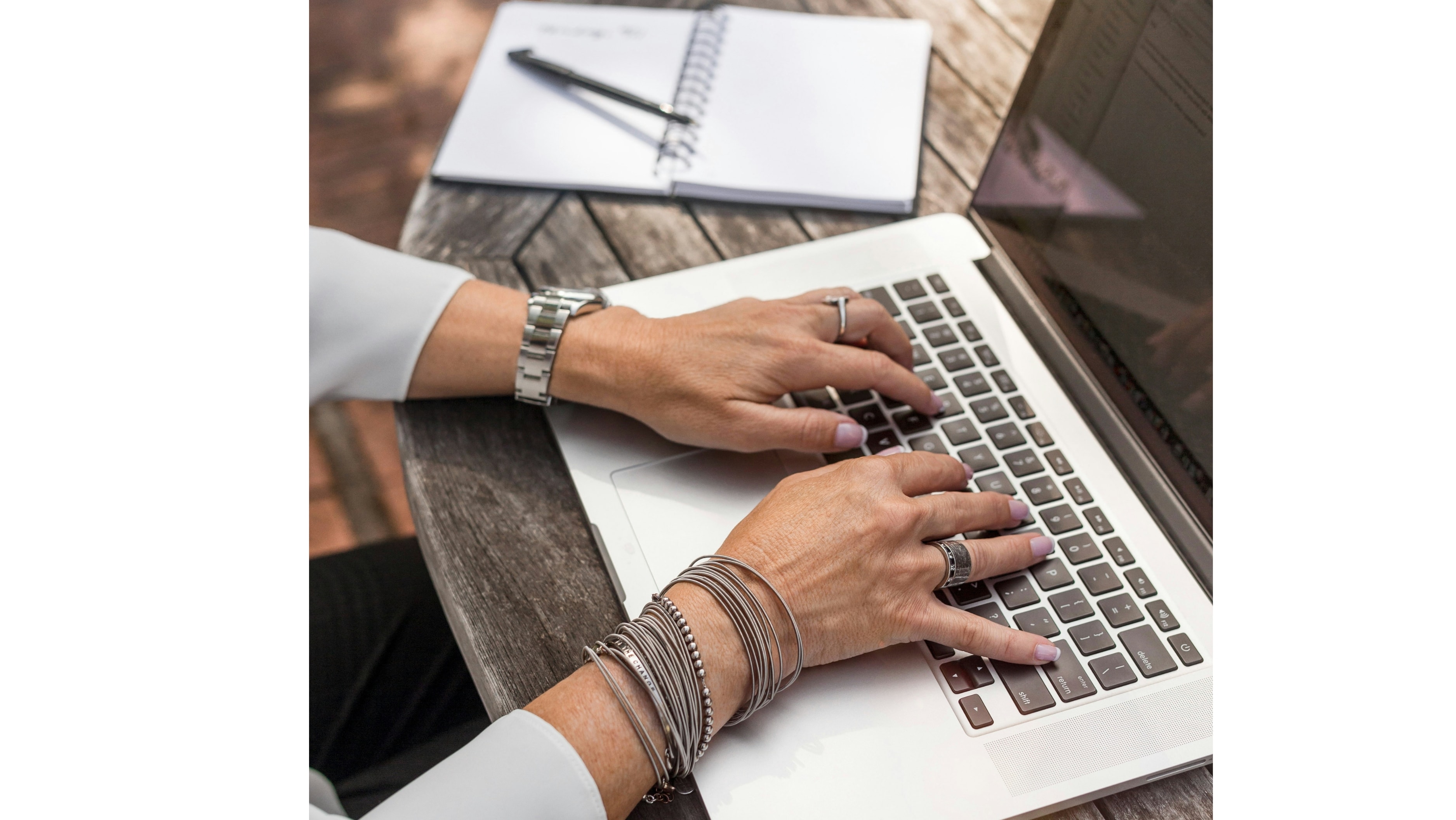 Kvinna med uppslagen laptop med fingersättning tangentbordet