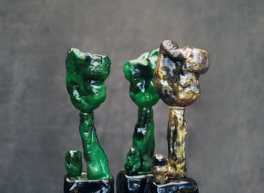 Statyetter, två gröna och en guld