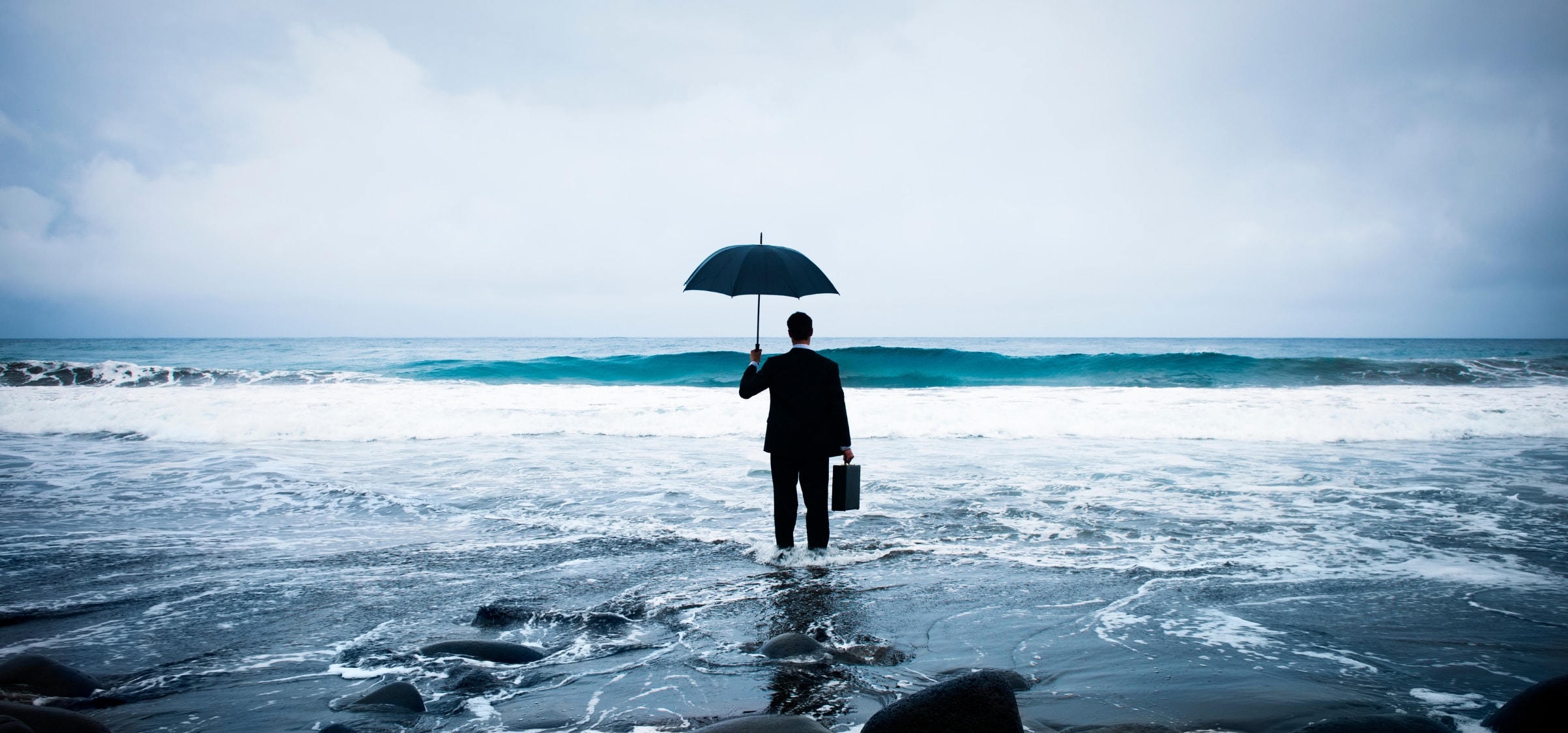 En man som står på en strand med ett paraply