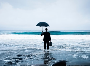 En man som står på en strand med ett paraply