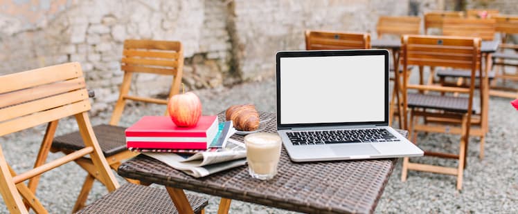 Laptop, bokhög och äpple utomhus
