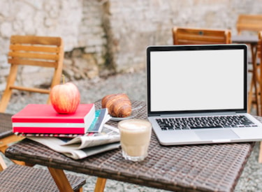 Laptop, bokhög och äpple utomhus