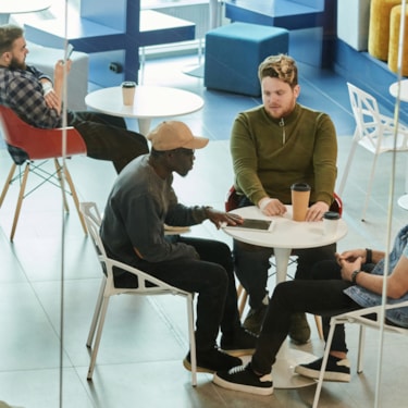 En grupp personer som sitter runt ett bord och pratar.